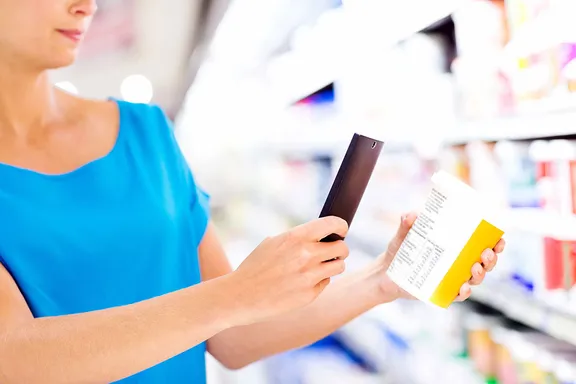 Woman scanning a barcode of a product with her mobile phone in a supermarket