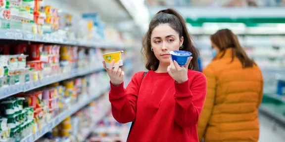 Woman holding up two products, one in each hand and comparing them